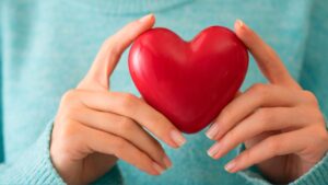 Young woman holding a red heart